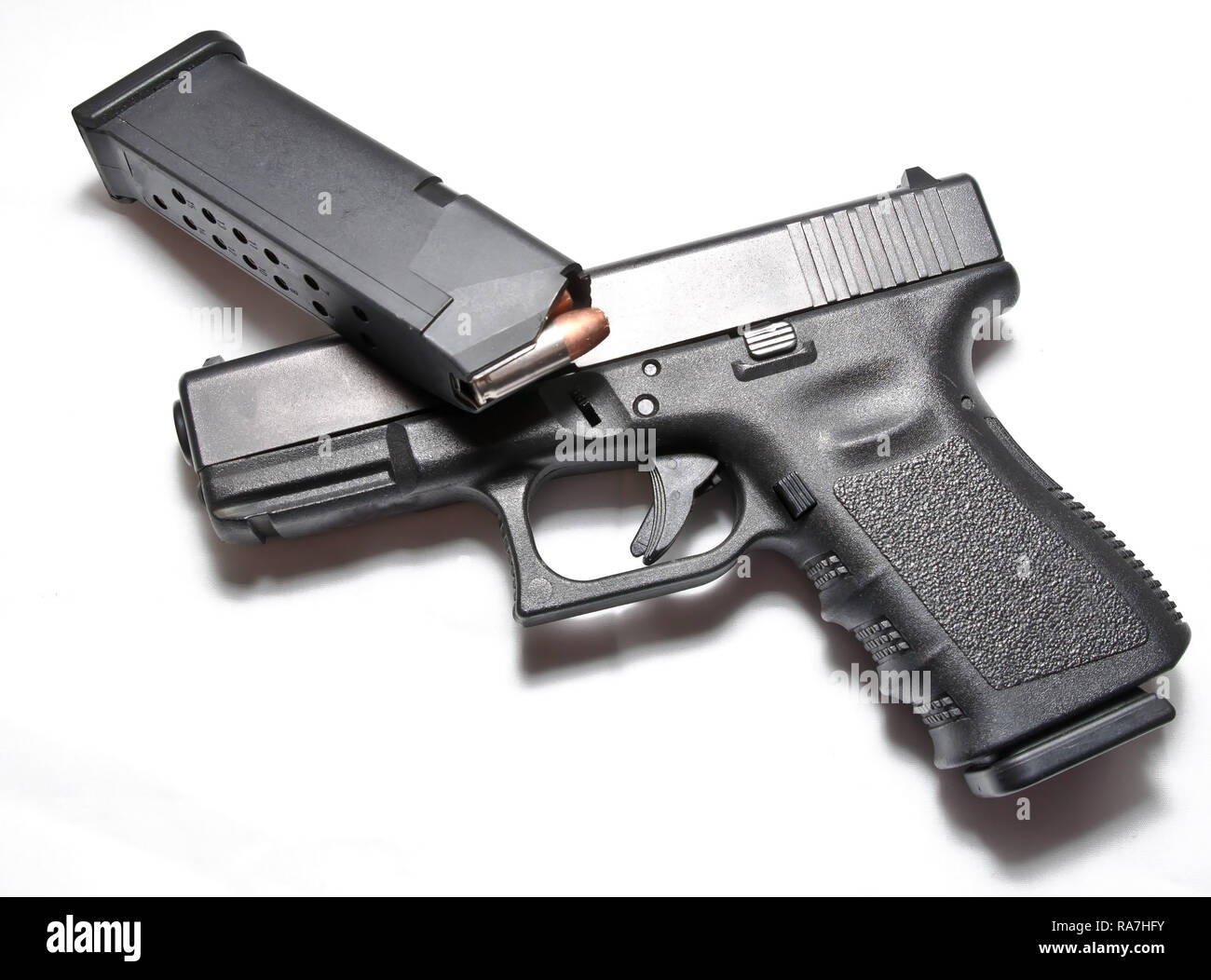 Un pistolet noir semi-automatique avec un pistolet chargé magazine portant sur le dessus de celui-ci sur un fond blanc Banque D'Images