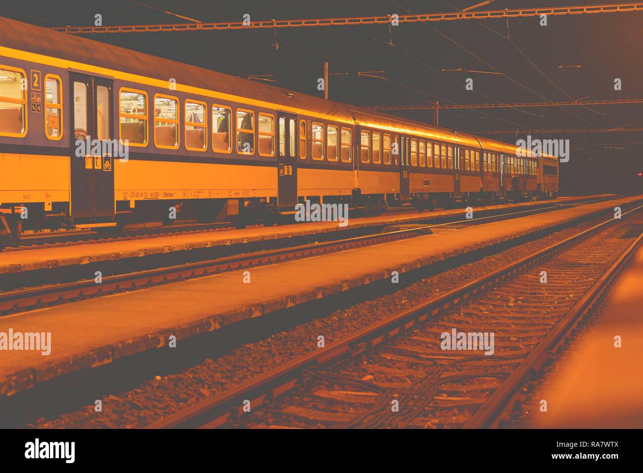 Train bleu et blanc debout à une petite gare sans toit la nuit en République tchèque. European train Banque D'Images