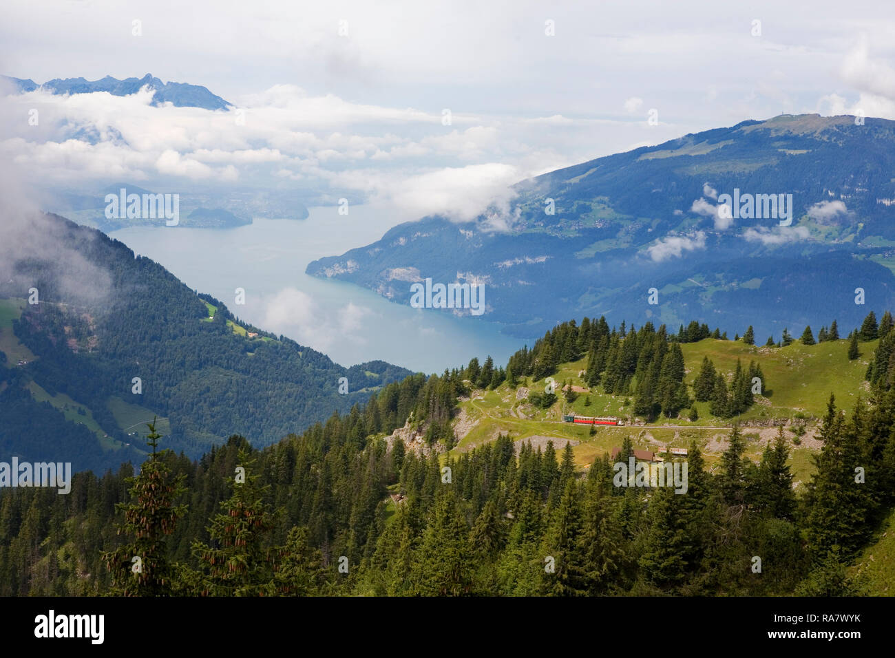 Train : Gare Schynige Platte est poussé vers le haut une forte pente à Bigelti, avec le Thunersee dans la distance, Oberland Bernois, Suisse Banque D'Images