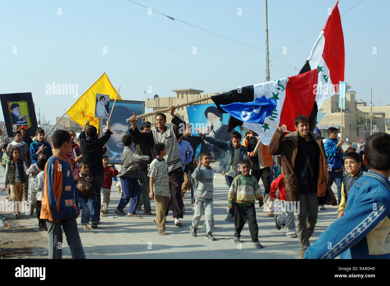 Le 15 décembre 2005, une foule d'irakiens défilent dans les rues avec des photos de leur candidat et agitaient des drapeaux iraquiens après qu'ils ont voté. Le vote a été fait dans le cadre de l'opération Iraqi Freedom. Banque D'Images