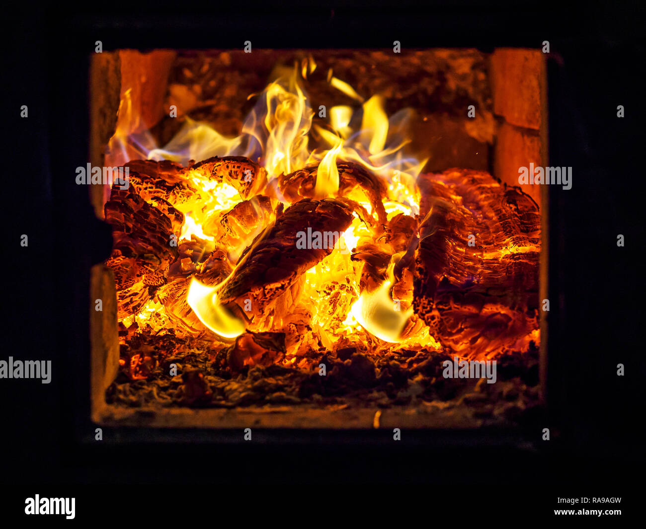 Flamme jaune de bois brûlant dans un four. Banque D'Images Flamme jaune de bois brûlant dans un four. Banque D'Images