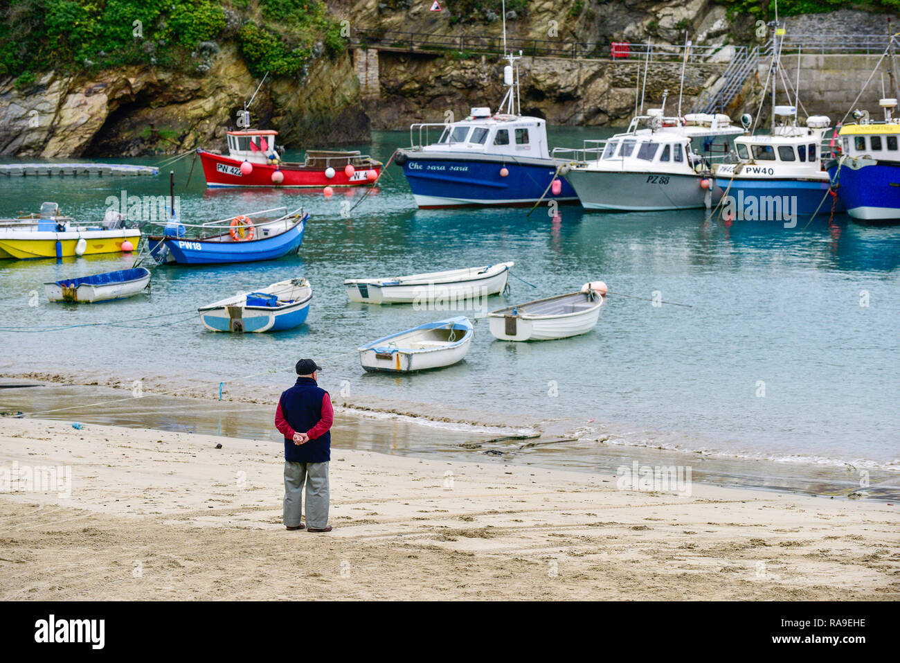 Un homme debout sur la rive à Newquay Harbour Harbour à Newquay en Cornouailles. Banque D'Images
