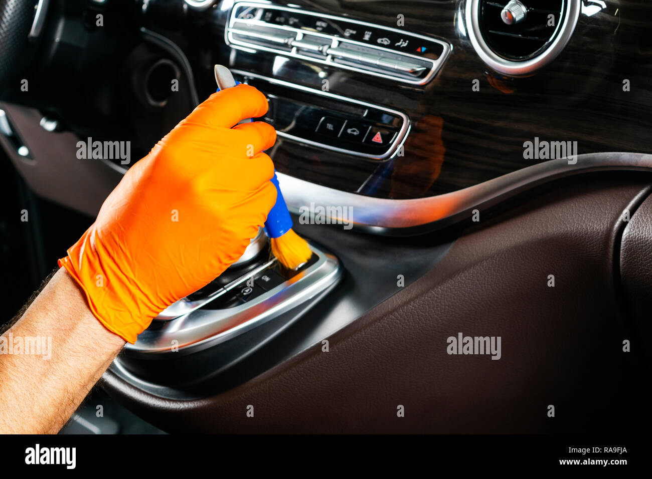 Un homme en voiture avec un chiffon de nettoyage et une brosse. Esthétique auto. Focus sélectif. Esthétique auto. Nettoyage avec une brosse. Nettoyage des travailleurs. Nettoyage de la brosse et solut Banque D'Images
