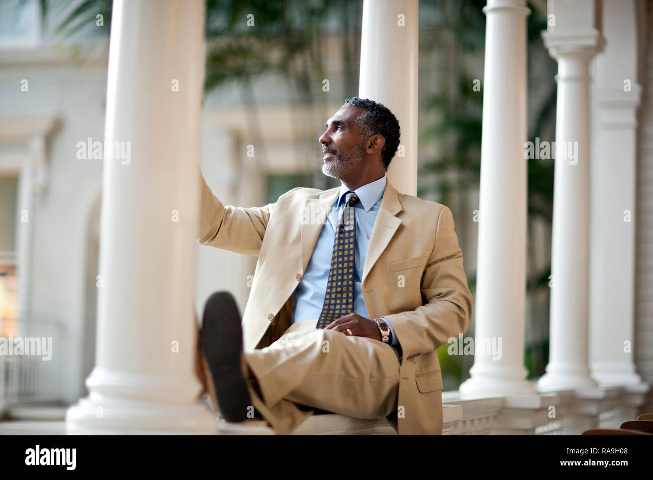 Mature businessman sitting par des piliers en face de son hôtel. Banque D'Images