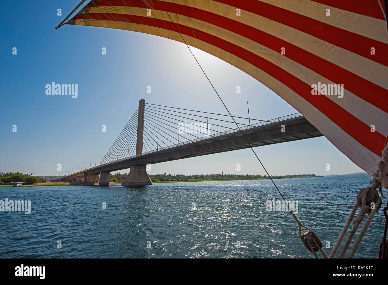 Grand traditionnel égyptien de luxe dahabeya river boat sail à rayures sur le Nil sous pont à haubans Banque D'Images