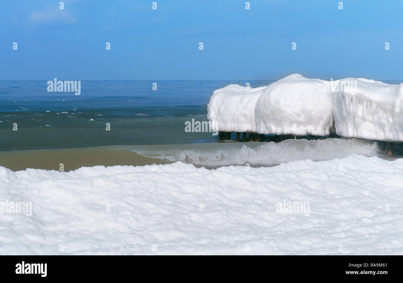 La glace sur le brise-lames, sur la côte de la mer couverte de neige Banque D'Images