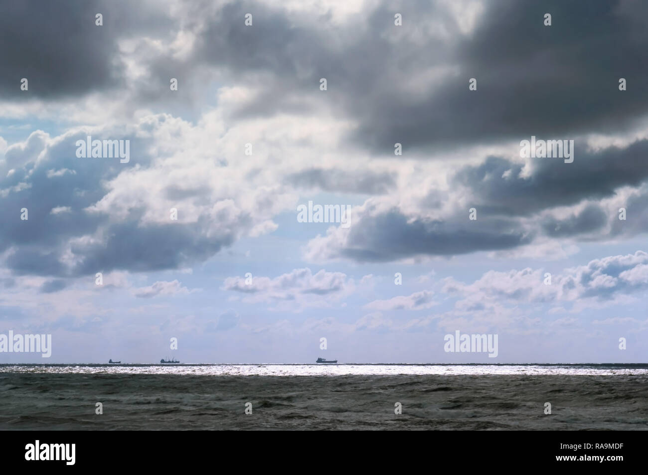 Mer agitée, ciel sombre, les navires à l'horizon Banque D'Images