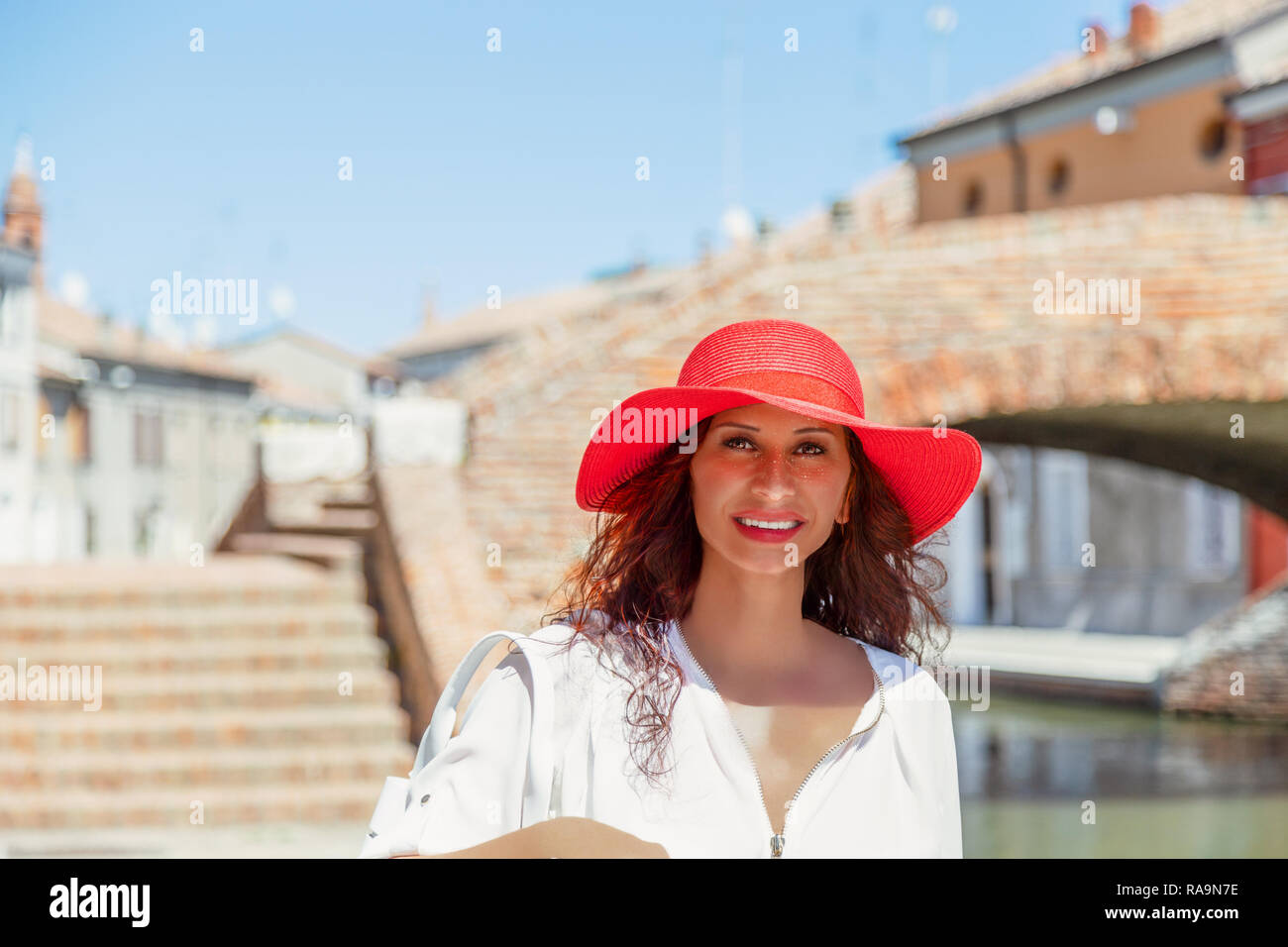 Heureux touriste avec large hat walking in ville italienne. Elle a Milieu Easterm fonctions somatiques Banque D'Images