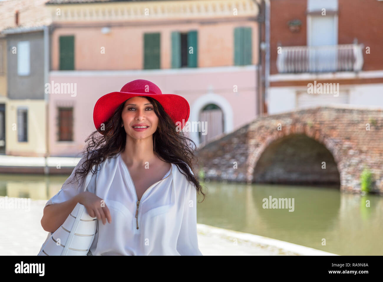 Heureux touriste avec large hat walking in ville italienne. Elle a Milieu Easterm fonctions somatiques Banque D'Images