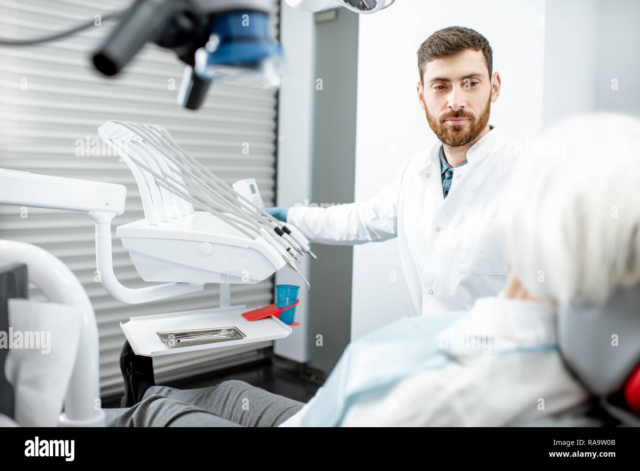 Beau dentiste au cours de la consultation avec les hauts femme dans le cabinet dentaire Banque D'Images