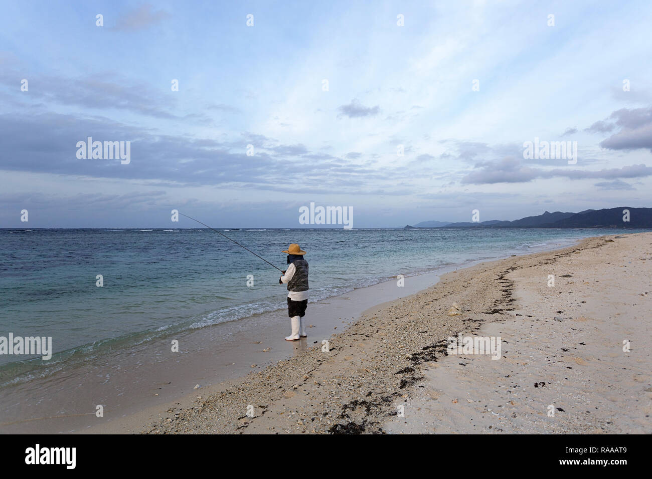 Pêcheur la pêche dans les eaux claires de Yonehara beach, Île Ishigaki-jima, Îles Yaeyama, Okinawa Prefecture, Japan Banque D'Images