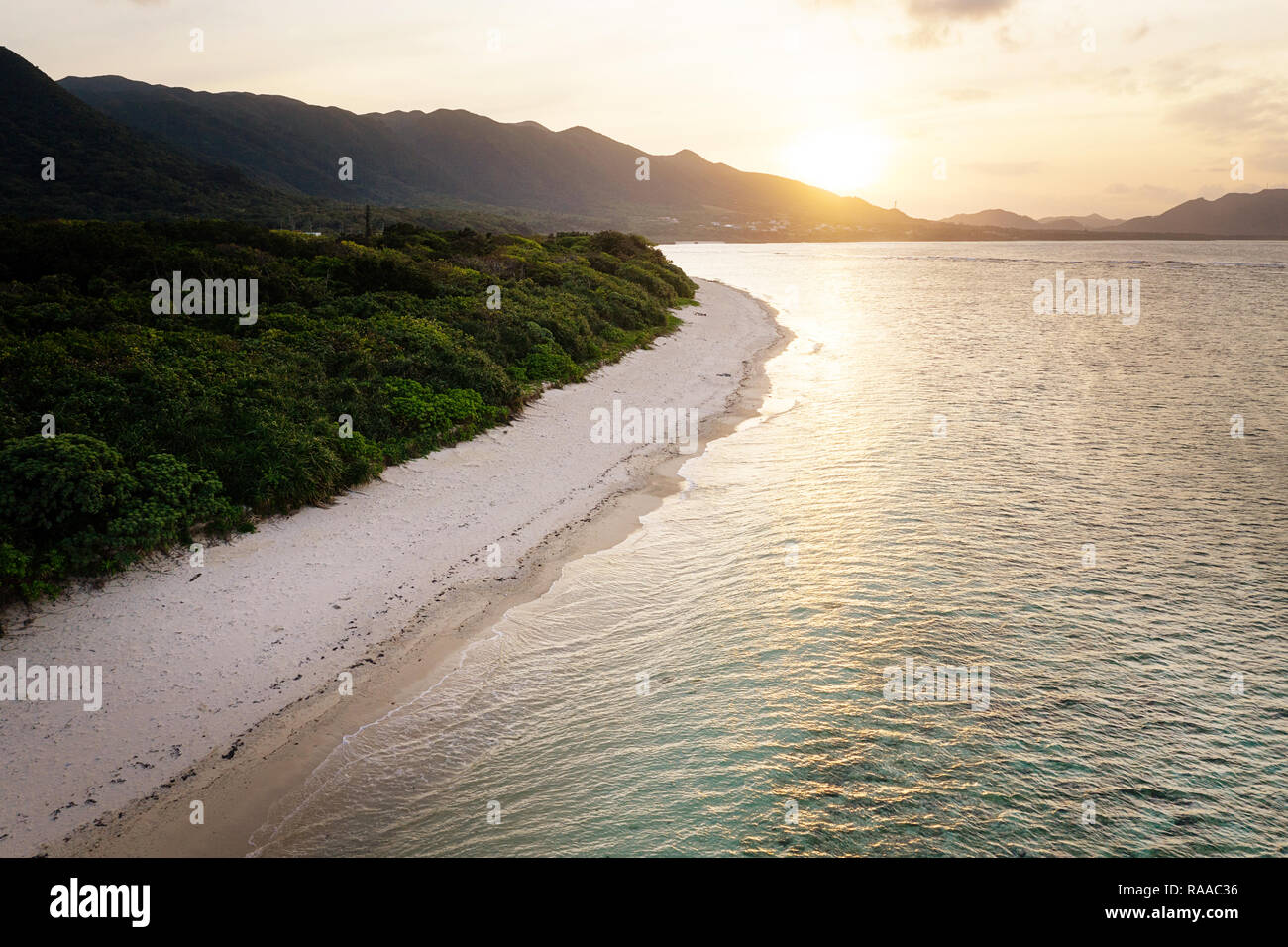 Vue aérienne sur l'île tropicale unique avec des montagnes, des plages de sable blanc et de récifs coralliens, au coucher du soleil, prise par drone, Ishigaki, Japon Banque D'Images