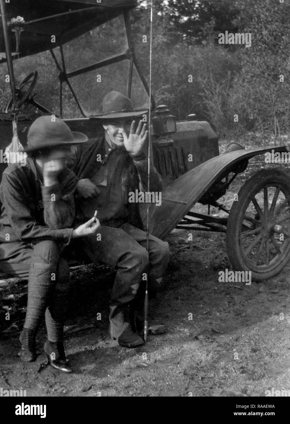 Un jeune couple de clowns autour assis sur le marchepied de leur période location lors de l'obtention de prêts pour les poissons, ca. 1925. Banque D'Images