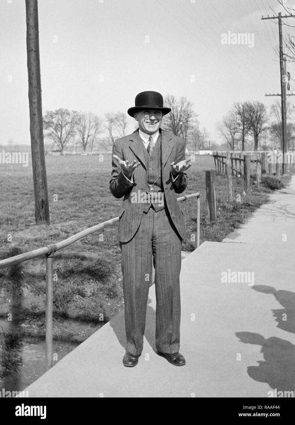 Un homme avec un chapeau melon, heureusement des gestes ca. L'année 1930. Banque D'Images