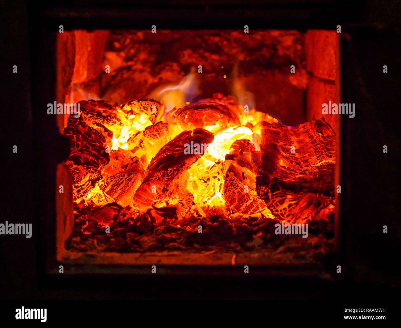 Flamme jaune de bois brûlant dans un four. Banque D'Images Flamme jaune de bois brûlant dans un four. Banque D'Images