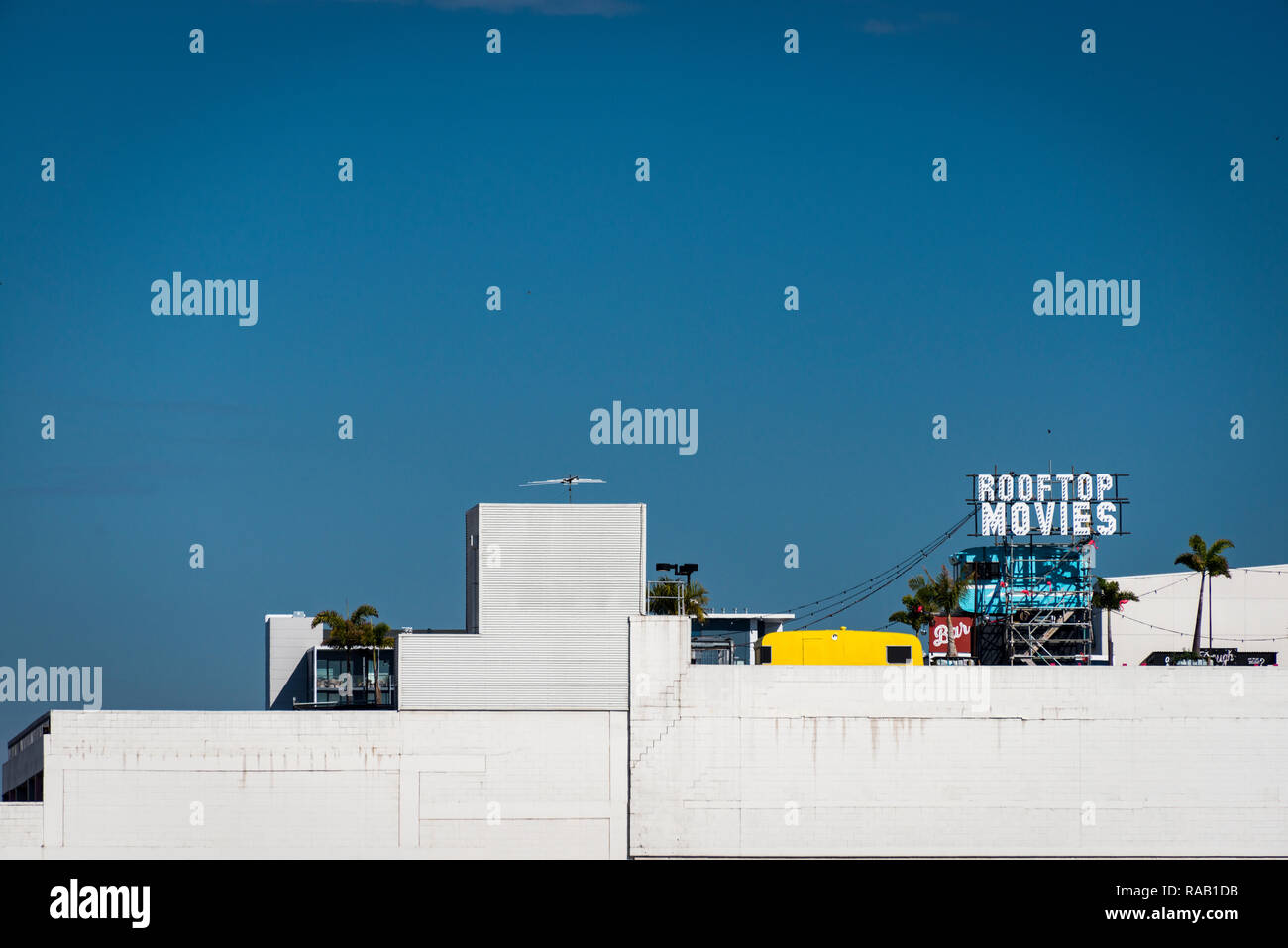 Un signe pour les films sur le toit d'un bâtiment en béton blanc contre un ciel bleu vif Banque D'Images