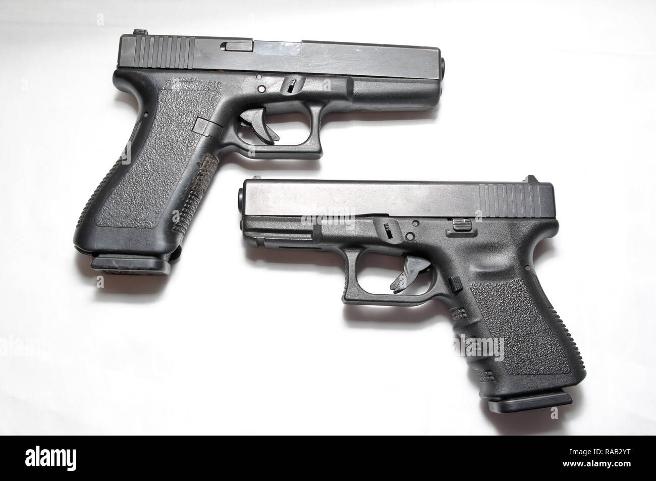 Deux pistolets semi-automatique noir, un 9mm et un calibre 40 sur un fond blanc montrant les différentes tailles d'eux Banque D'Images