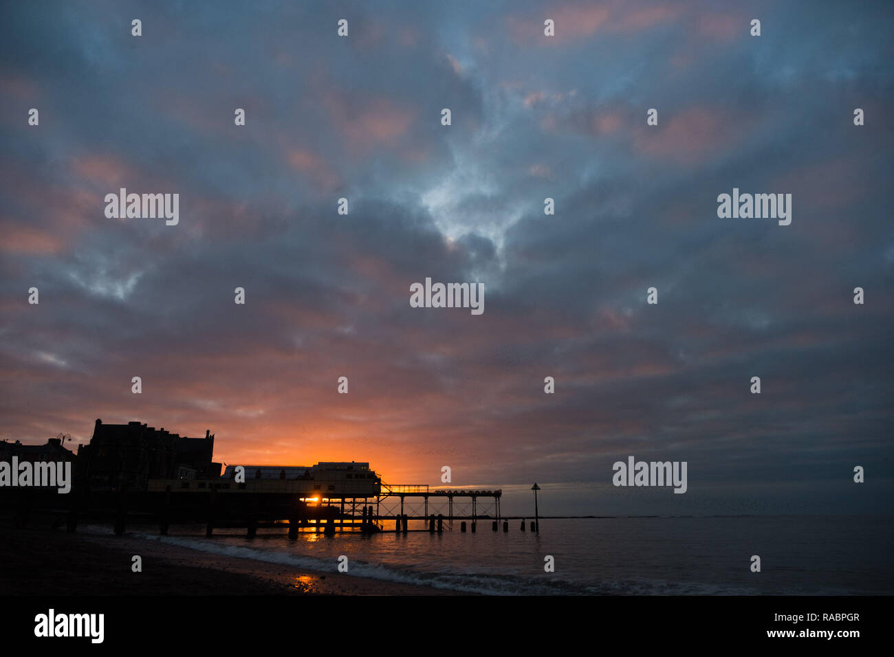 Aberystwyth, Pays de Galles, Royaume-Uni. 06Th Jan, 2019. Météo France : à la fin d'un mat gris et froid jour de janvier le soleil fait une brève apparition en tant qu'elle place sur le Royal Pier en tandem avec l'étourneau de repos à Aberystwyth sur la côte ouest de la Baie de Cardigan au Pays de Galles. Crédit photo : Keith morris/Alamy Live News Banque D'Images