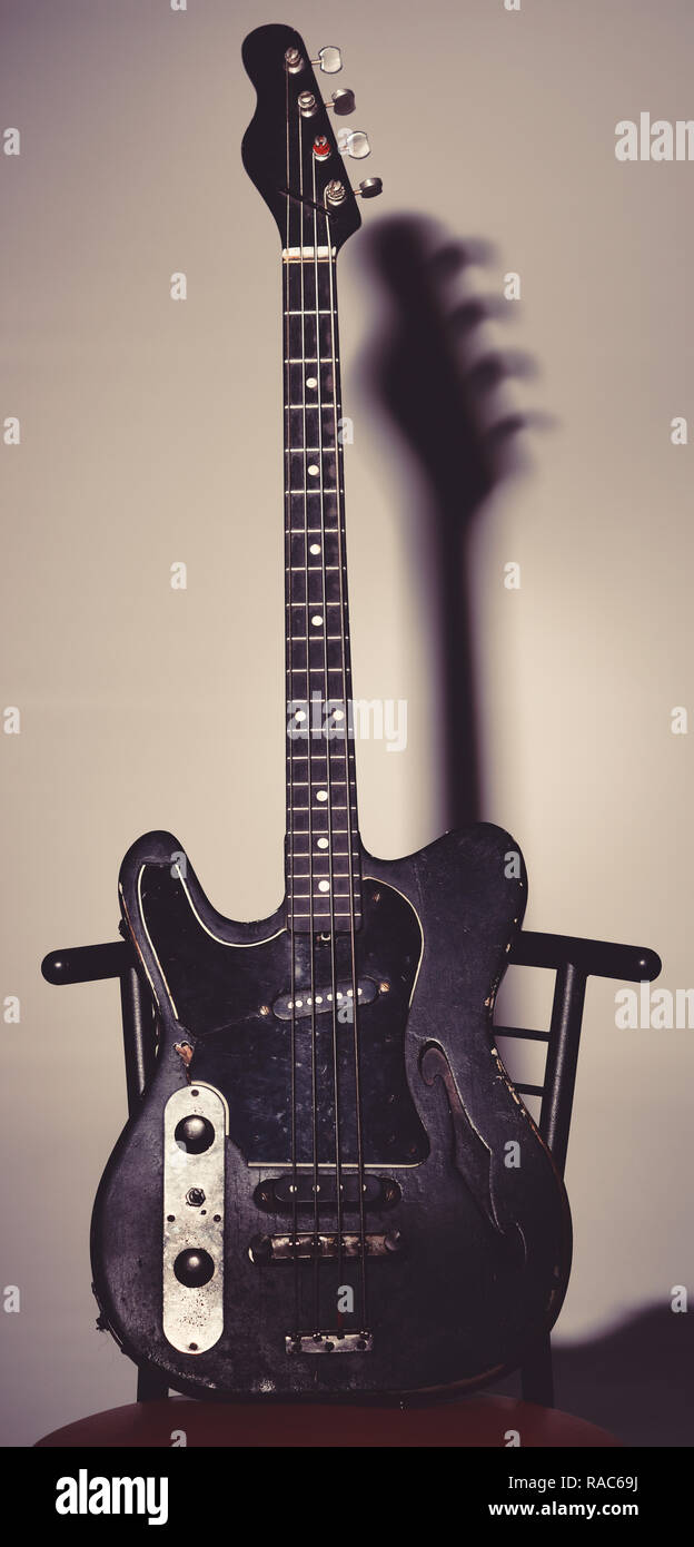 Instrument de musique à quatre cordes pour jouer metal ou de jazz. Hard  rock et musique concept. La guitare dans le noir profond de la couleur sur  fond noir avec l'ombre. La