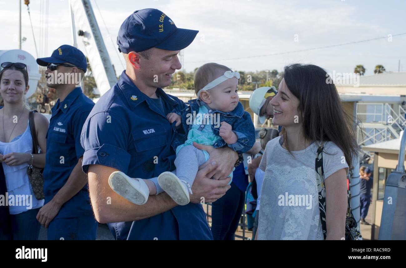 Un garde-côte de valeureux équipage rencontre avec sa femme et son enfant après son retour du navire au port d'attache à la Station Navale de Mayport, Florida après 5 semaines d'interdiction migrants patrouille. Au cours de leur déploiement dans le détroit de Floride, le valeureux équipage secourus, soignés et rapatrié 307 émigrés cubains qui tente d'entrer aux États-Unis. La Garde côtière américaine Banque D'Images