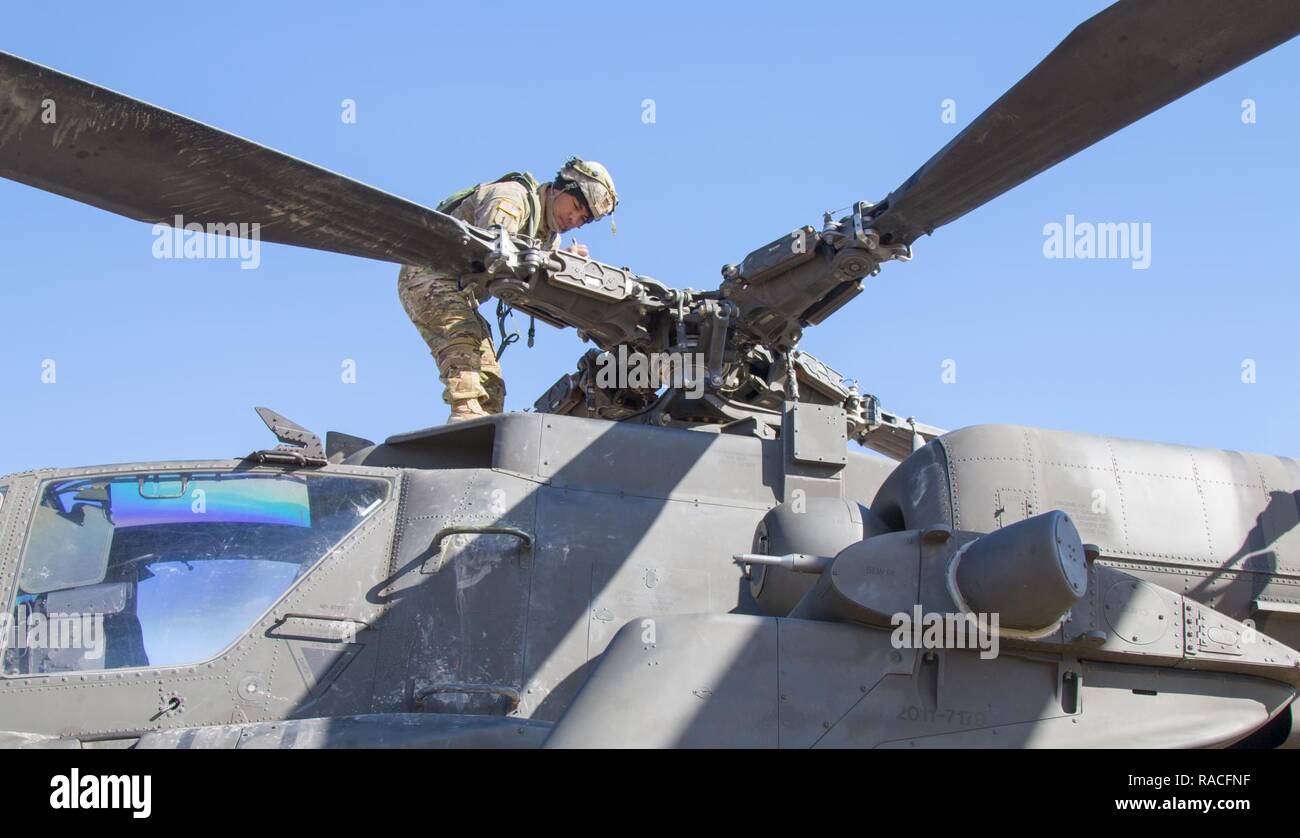 Le sergent de l'armée américaine. Alvin Atalig un inspecteur technique avec Delta Co., 1er Bataillon de Reconnaissance, d'attaque, 25e Brigade d'aviation de combat confirme de numéros de série sur un AH-64 Apache à Fort Irwin, en Californie, le 24 janvier 2017. C'est 1-25ème ARB's première rotation au Centre National d'entraînement. Cnt fournit des unités et du personnel militaire des États-Unis avec des scénarios de formation de pré-déploiement dans tous les aspects des conflits armés. Banque D'Images