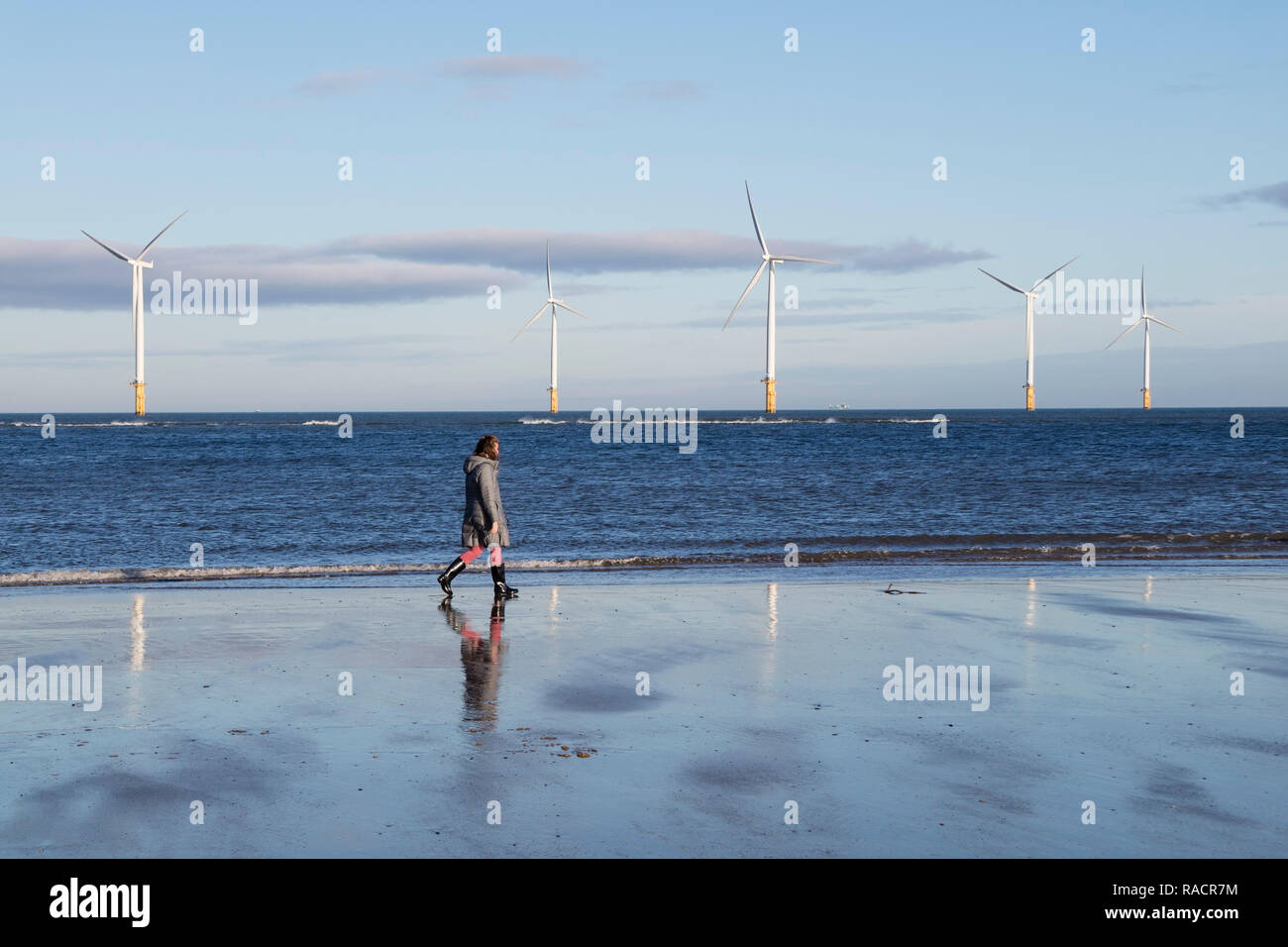Personne marchant passé Partie de la turbine 27 62MW d'éoliennes près de Teesside Redcar, North Yorkshire, UK Banque D'Images