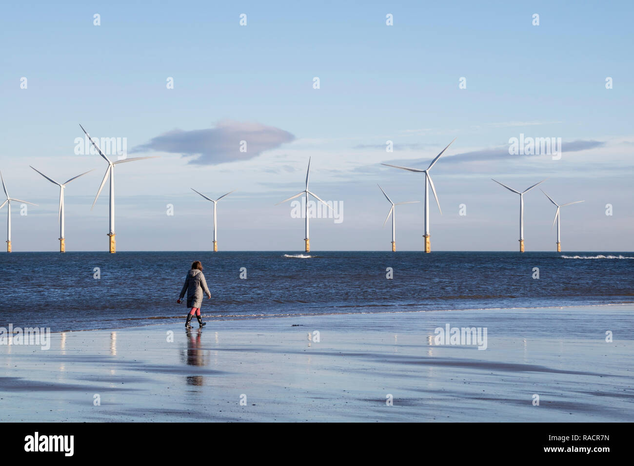 Personne marchant passé Partie de la turbine 27 62MW d'éoliennes près de Teesside Redcar, North Yorkshire, UK Banque D'Images