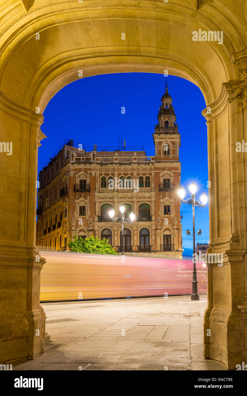 Light trails du tramway passant bâtiment historique à Plaza Nueva au crépuscule, Séville, Andalousie, Espagne, Europe Banque D'Images