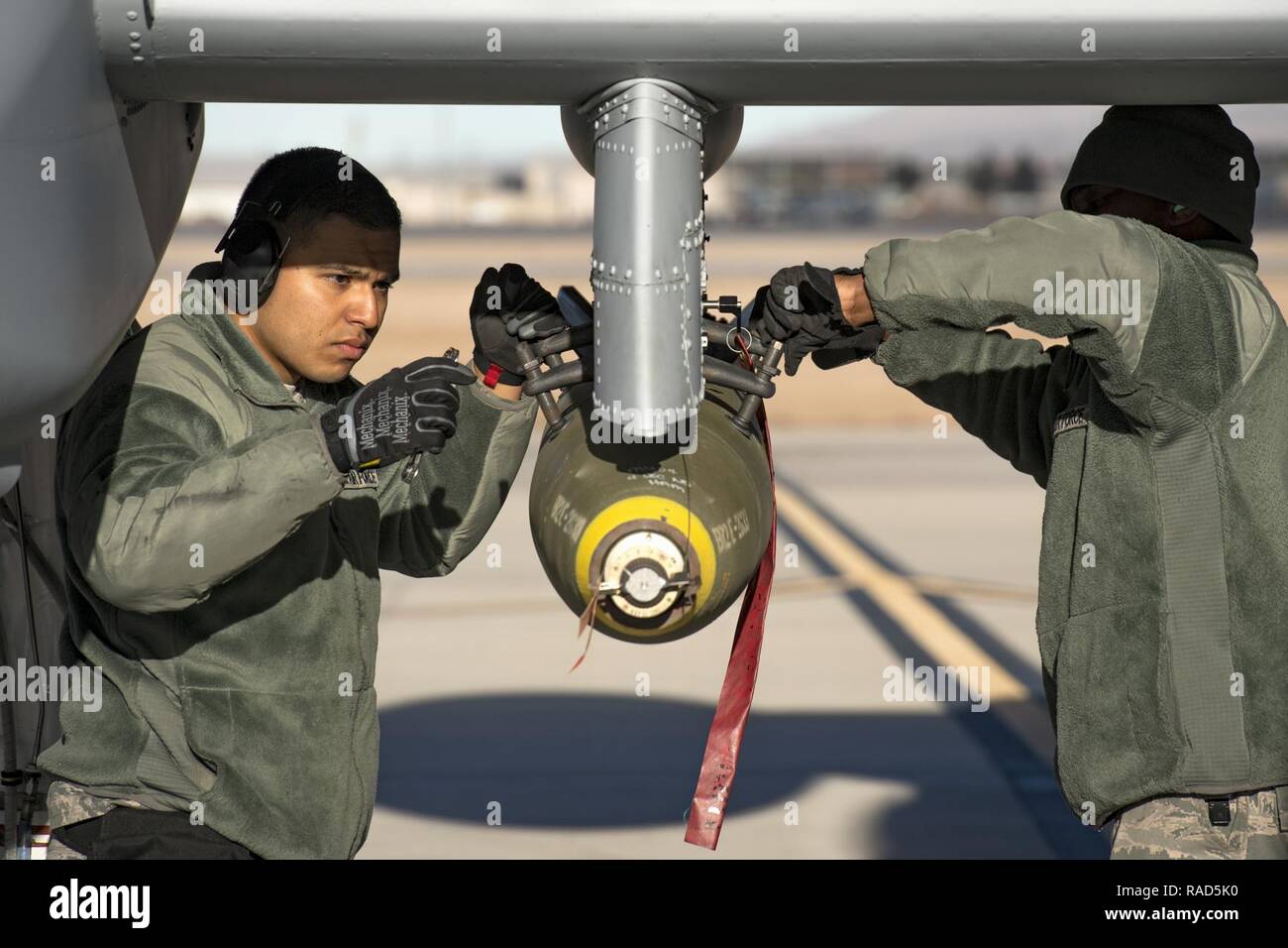 Airman First Class Carlos Quintanilla, gauche, et le sergent. Tayrell Washington, 74e Unité de maintenance d'aéronefs de la charge d'armes les membres de l'équipe, obtenir une marque d'usage général 82 bombe au bas d'un A-10C Thunderbolt II pendant l'Flag-West vert 17-03, le 24 janvier 2017, à Nellis Air Force Base, Nevada aviateurs armes activé l'instruction interarmées au cours de l'exercice de deux semaines par le chargement d'armes, l'inspection et l'entretien des systèmes de jets d'armes à sous-munitions. Certaines des munitions live inclus la Marque 82 et 84 bombes à usage général, fortement explosif 30mm rondes et incendiaires le 500 GBU-12 Paveway II livre-guide laser Banque D'Images