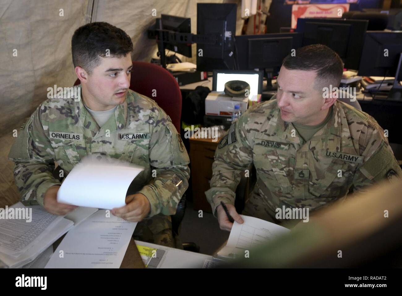 Le Sgt. 1re classe Andrew Davis, un originaire d'Athens, Alabama et la normalisation sous-officier dans le 69e d'artillerie de défense aérienne "Top Notch" Brigade, vérifie le 1er Bataillon, 43e Régiment d'artillerie de défense aérienne du programme de maintenance avec la CPS. Daniel Ornelas (à gauche), un McAllen, Texas, indigènes et de maintenance du système de tracker avec le bataillon, le 23 janvier dans l'armée américaine commande centrale sur la zone de responsabilité. Davis commentaires les états de l'équipement jusque dans les moindres détails pour confirmer l'exactitude. Banque D'Images