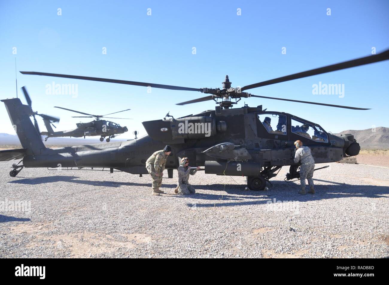 Un serveur Apache AH-64D s'apprête à atterrir à l'armement et de l'avant un point de ravitaillement à Doña Ana, N.M., comme des soldats affectés à la Brigade d'aviation de combat, 1re Division blindée, charger et faire le plein de munitions, un hélicoptère le 25 janvier 2017. Banque D'Images