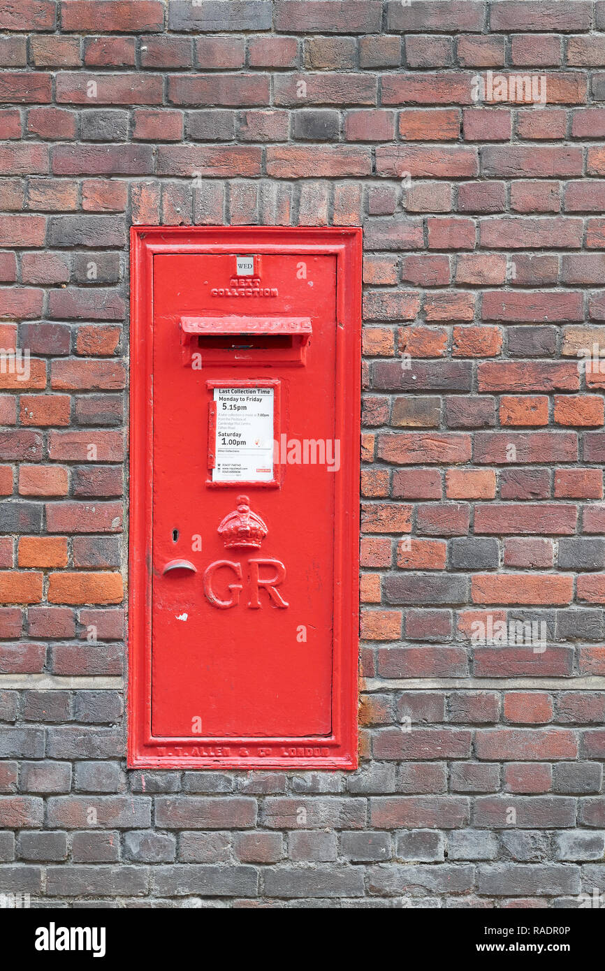 Red post box encastrée dans un mur de brique du Sidney Sussex College, Université de Cambridge, Angleterre. Banque D'Images