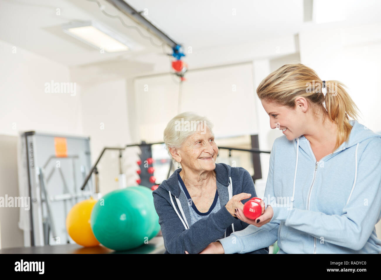 Thérapeute en réadaptation physique aide les femmes dans la formation de poids pour la force et de conditionnement physique Banque D'Images