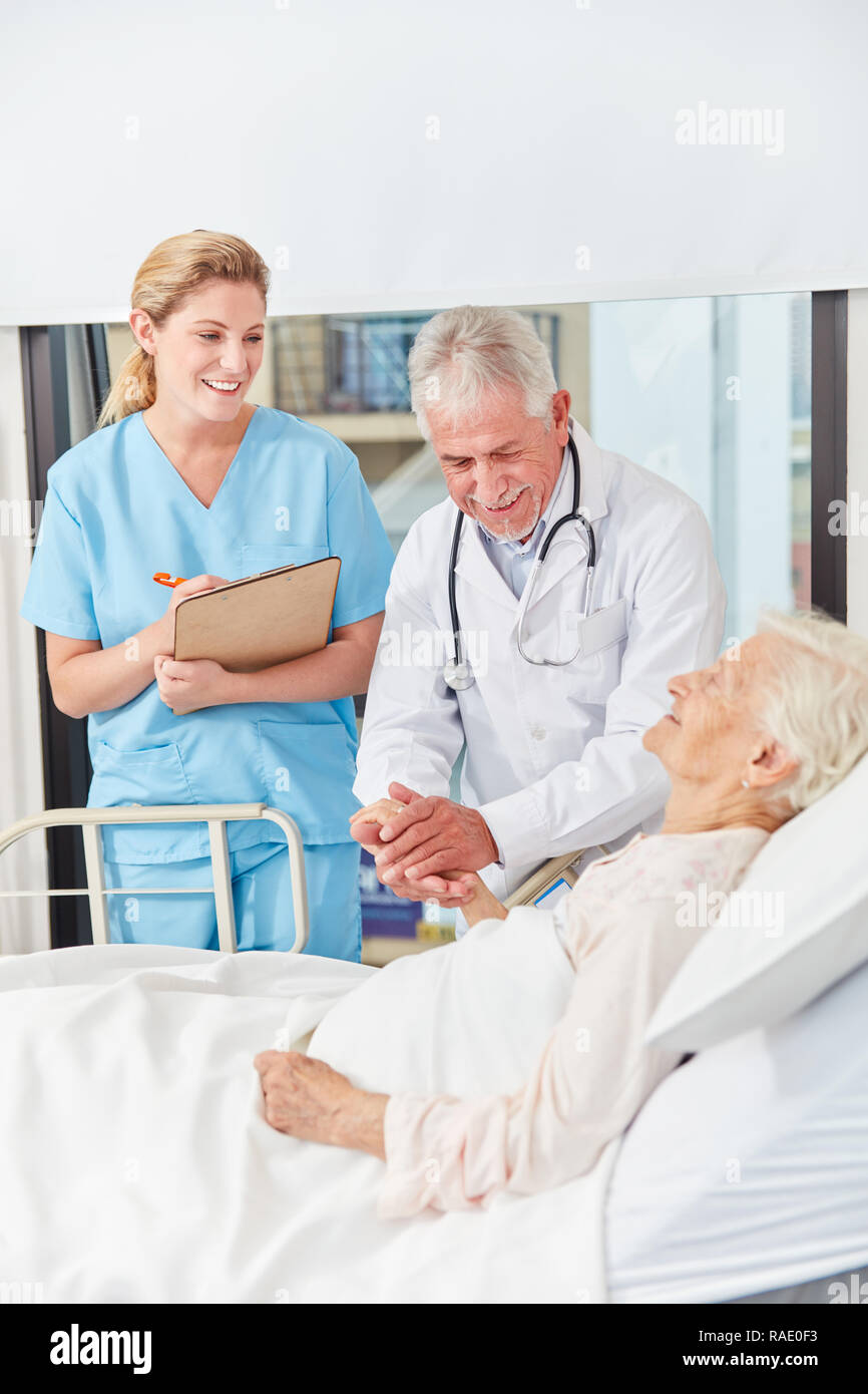 Médecin réalise une histoire de conversation avec un ancien patient dans le lit d'hôpital Banque D'Images