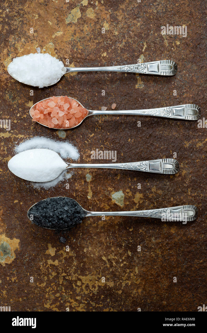 Quatre différents types de sel. Depuis le haut : Flocons de sel de mer, sel rose de l'Himalaya, sel de cuisine, sel noir (charbon actif de sel). Banque D'Images