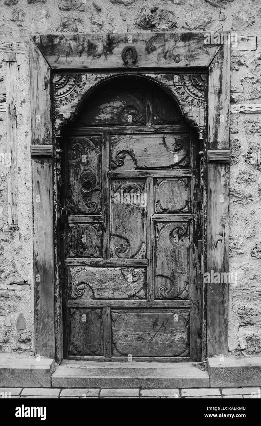 Vieille porte en bois avec poignée en ville antique de la ville d'Antalya, Turquie. Noir et blanc vertical la photographie en couleurs. Banque D'Images