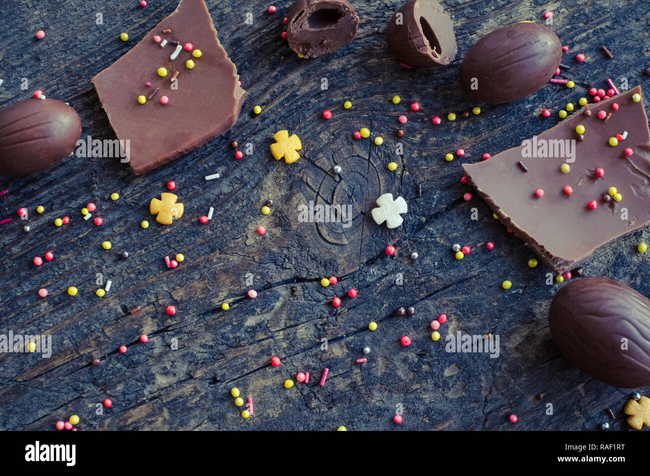 Composition de Pâques avec des œufs en chocolat et des morceaux de gros oeuf en chocolat sur fond de bois rustique ancienne avec place pour votre texte. Heureux Vacances de Pâques Banque D'Images