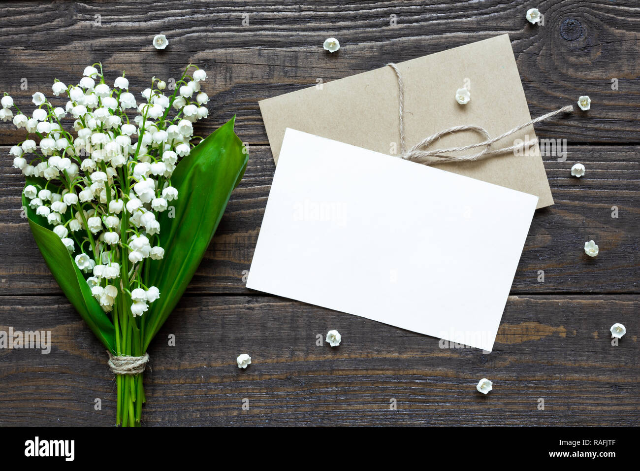 Blanc Blanc carte de vœux et enveloppe avec printemps muguet fleurs et bourgeons. valentines ou womens day background. Vue de dessus la maquette. Banque D'Images