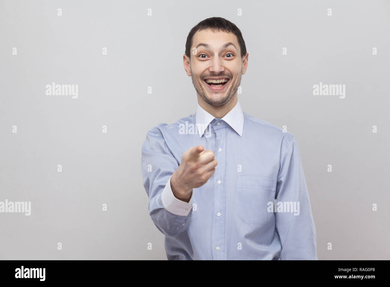 C'est qu'était vous ? Surpris en soies beau businessman in classic shirt bleu, permanent et de pointage à la caméra au visage surpris avec studio à l'intérieur. Banque D'Images C'est qu'était vous ? Surpris en soies beau businessman in classic shirt bleu, permanent et de pointage à la caméra au visage surpris avec studio à l'intérieur. Banque D'Images