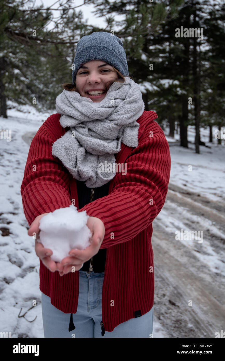 Jeune fille heureuse d'adolescent vêtu de vêtements d'hiver en jouant avec la neige en montagnes Troodos à Chypre Banque D'Images