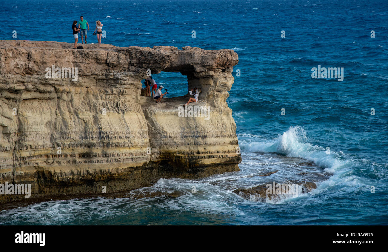Protaras, Chypre - 30 juillet 2018 : personnes debout et assis sur les rochers, en appréciant les eaux claires à la célèbre Cape Greco à Protaras en zone Banque D'Images