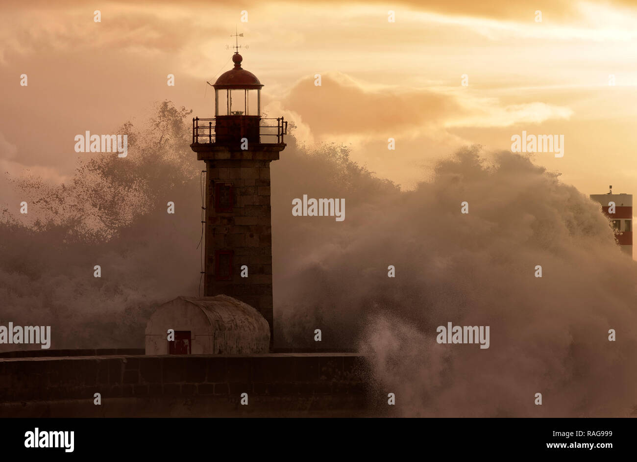 Les grandes vagues de tempête au phare au coucher du soleil. Amélioration de ciel. Banque D'Images