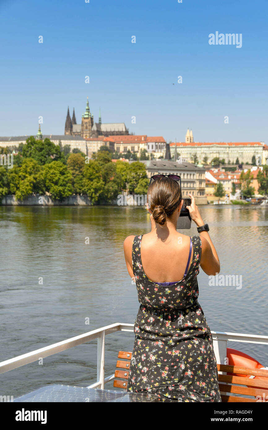 PRAGUE, RÉPUBLIQUE TCHÈQUE - Juillet 2018 : Personne à prendre des photos à partir d'un bateau-mouche sur la rivière Vltava à Prague. Dans l'arrière-plan est la Cathédrale St Tom Frager Banque D'Images