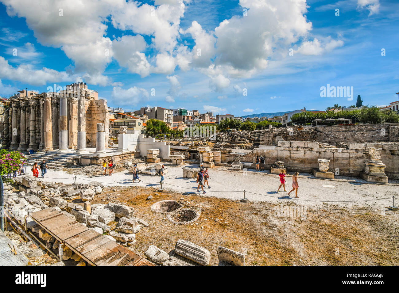 Les touristes visiter sur l'ancien mur ouest de bibliothèque d'Hadrien à l'Agora romaine, avec le populaire quartier du Plaka derrière, à Athènes, Grèce. Banque D'Images