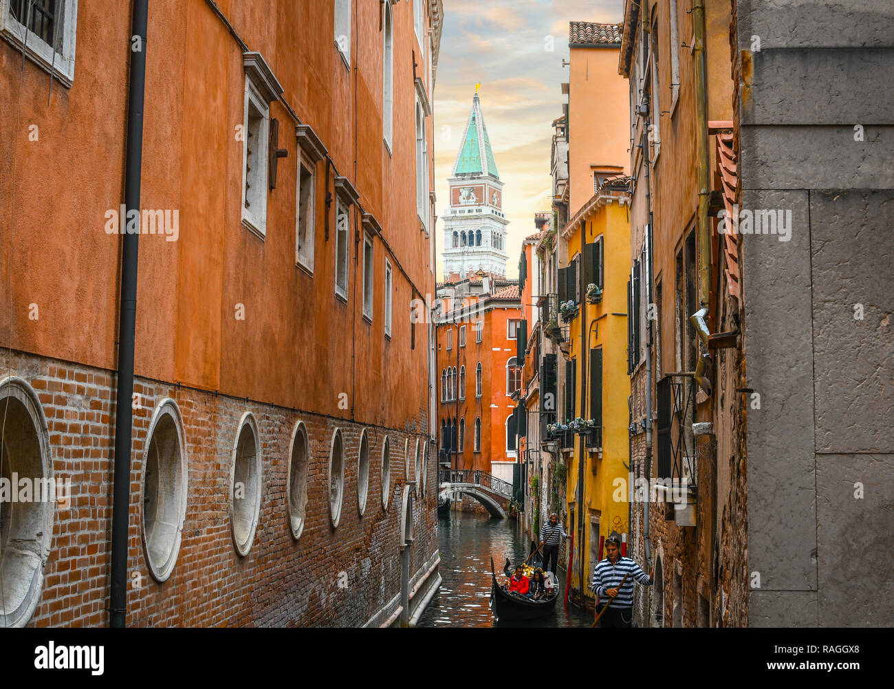 Deux Gondoliers transportent les touristes sur les gondoles dans un canal étroit avec le clocher en vue de Venise, Italie. Banque D'Images