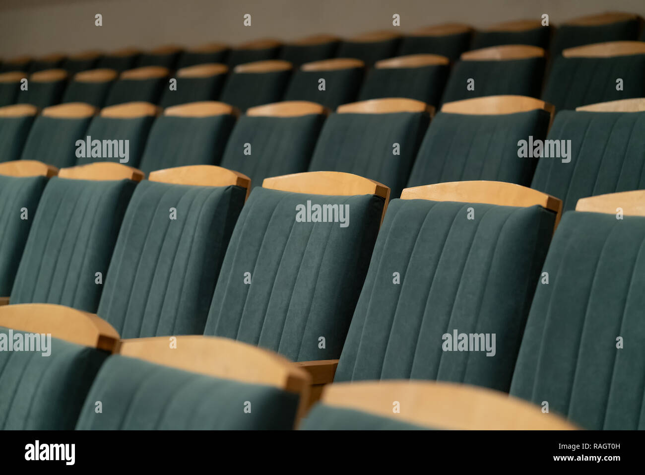 Fauteuil rembourré avec garniture verte. L'auditorium vide. Des chaises en bois. Banque D'Images