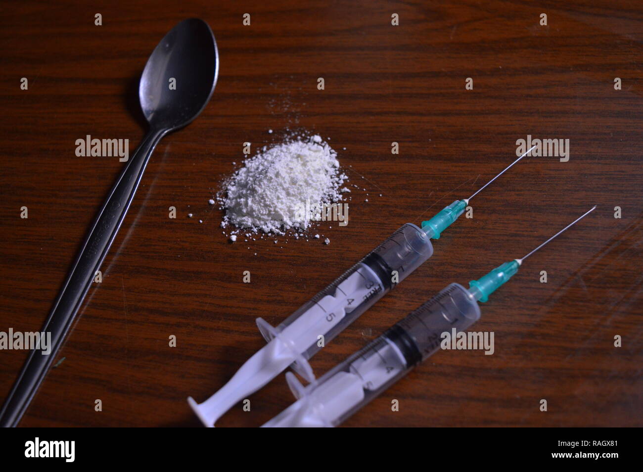 Les stupéfiants en préparation. Les aiguilles, et une cuillère de poudre blanche sur une table. Banque D'Images