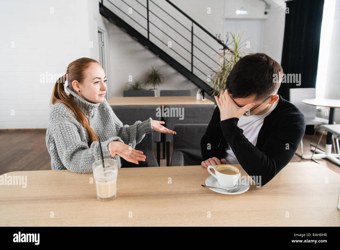 Mauvaise relation concept. L'homme et la femme en désaccord. Young couple sitting in cafe avoir querelle, offensé épouse et malheureux mari Banque D'Images