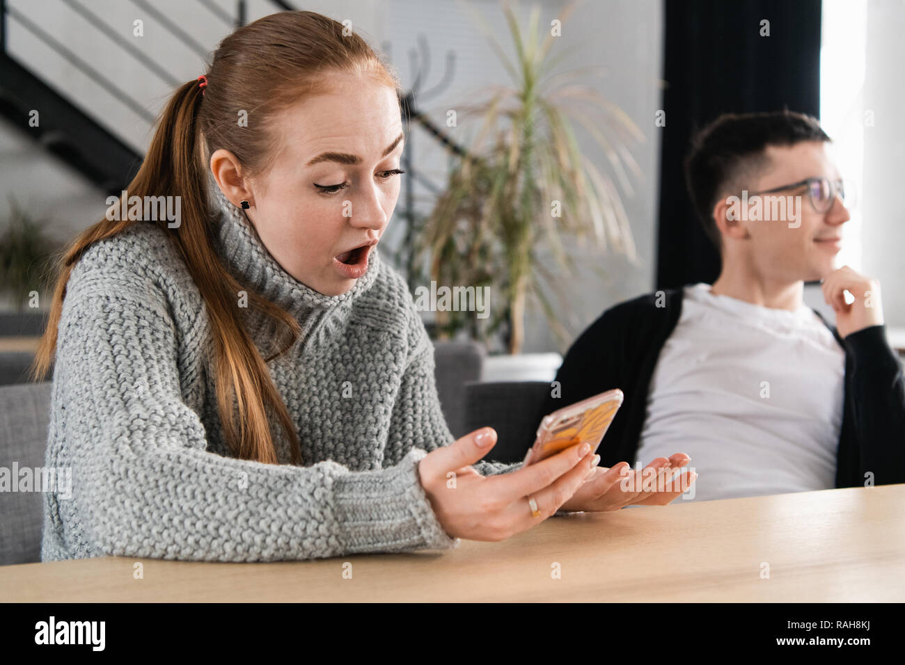Femme lisant son homme messages tricher sur son téléphone Banque D'Images