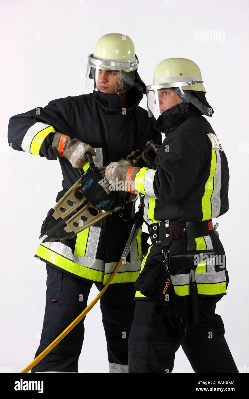 Les pompiers tenant un outil de l'éparpilleur hydraulique où les parties métalliques sont écartées pour sauver des personnes, professionnels Banque D'Images